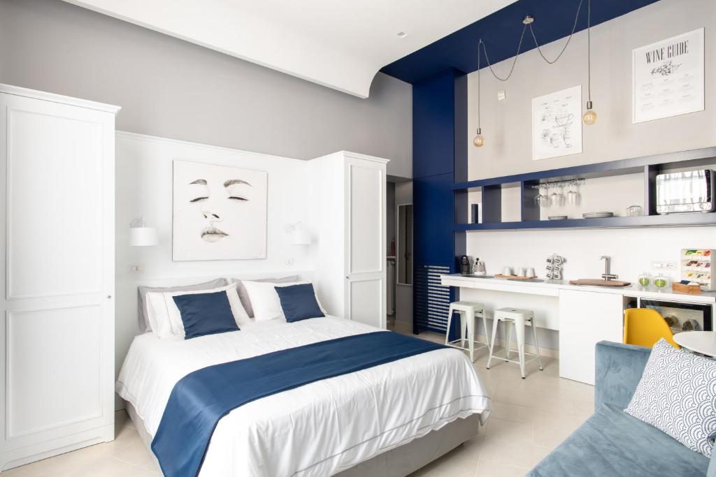 - une chambre blanche et bleue avec un lit et une cuisine dans l'établissement My Lodge Italy Centro Storico, à Naples
