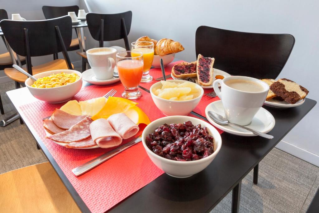 a table with breakfast foods and drinks on it at Hôtel Le Nautic in Arcachon