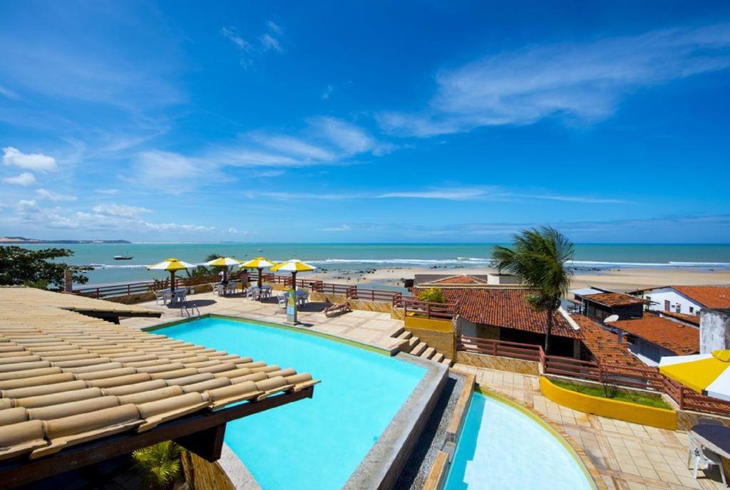 a resort with a swimming pool and a beach at Pipa's Bay Flats in Pipa