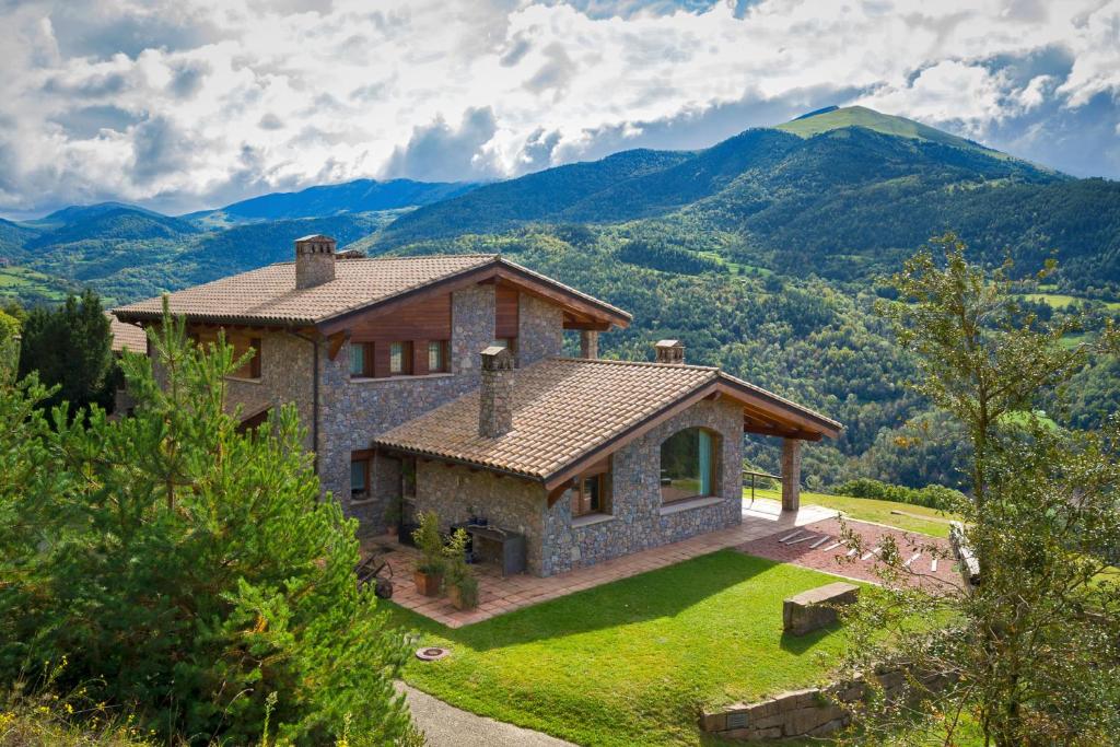 una casa con una montaña en el fondo en Serrat del Vent - Adults only, en Ribes de Freser