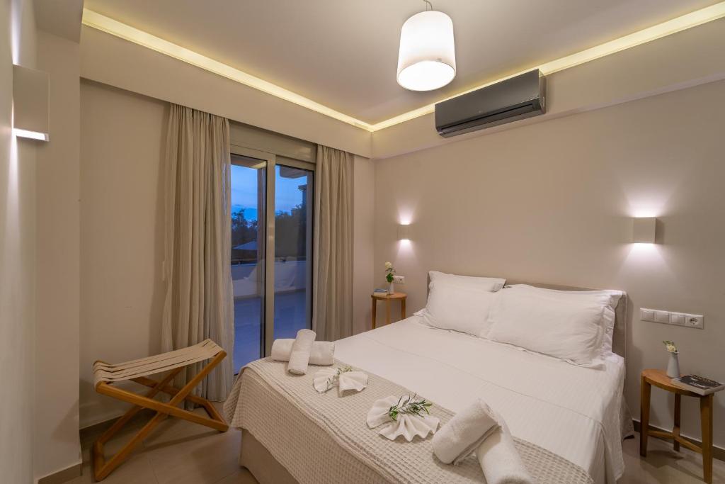 um quarto com uma cama e uma grande janela em Abelia Luxurious Villas em Finikounta