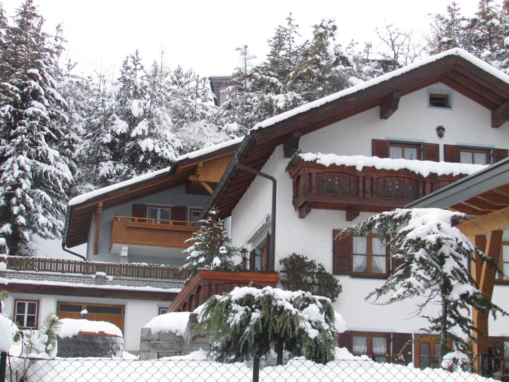 una casa ricoperta di neve con una recinzione di fronte di Ferienhaus Tschenett a Imst