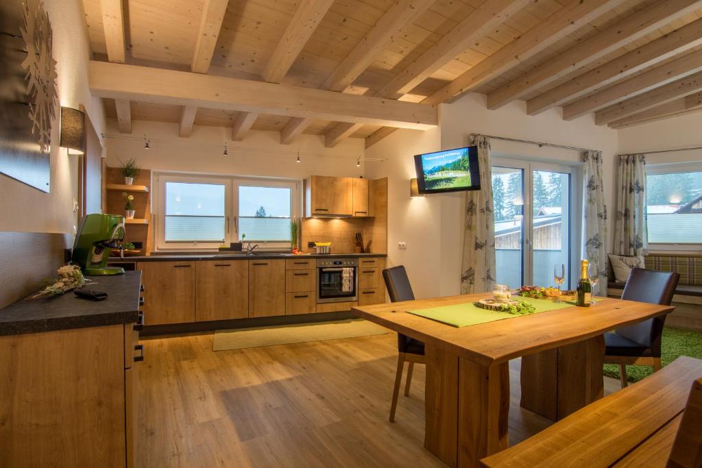 een keuken met een houten tafel en een eetkamer bij Ferienwohnung Lechleitner in Reutte