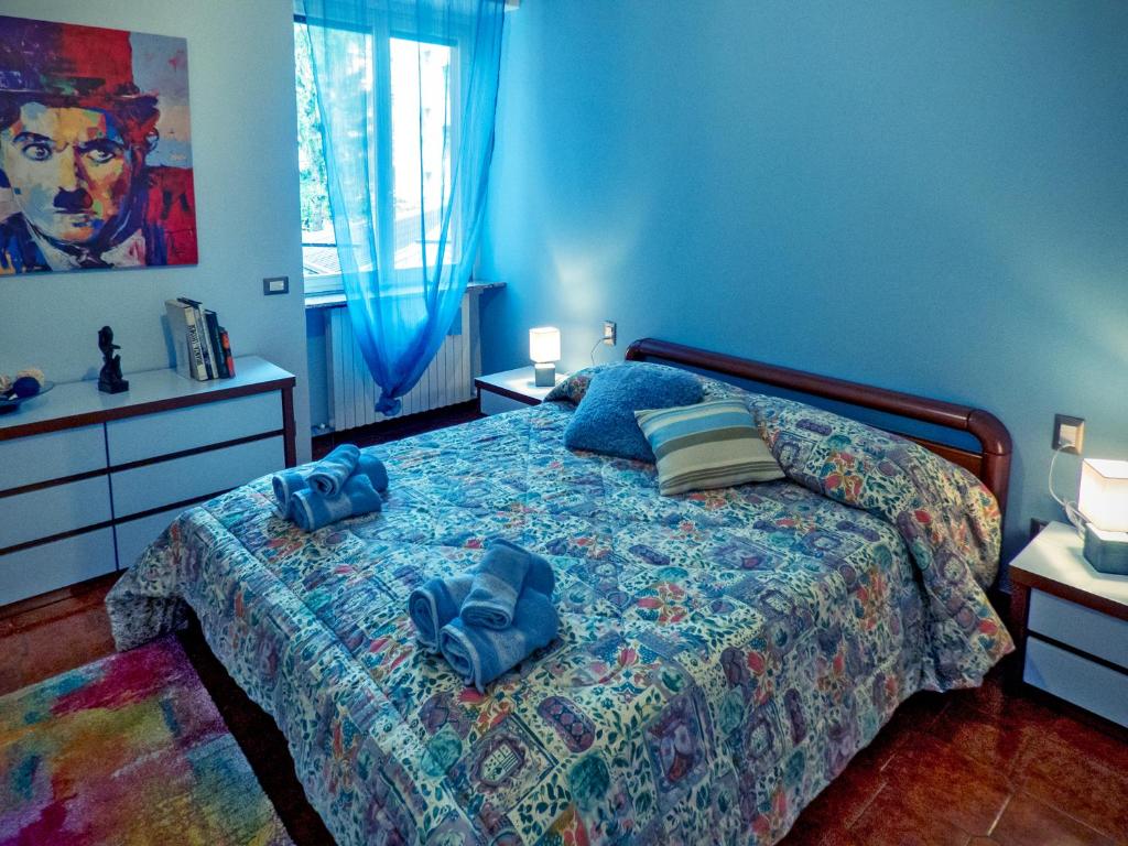 una camera da letto con un letto con lenzuola e cuscini blu di La Casa Sotto I Tigli a Lecco