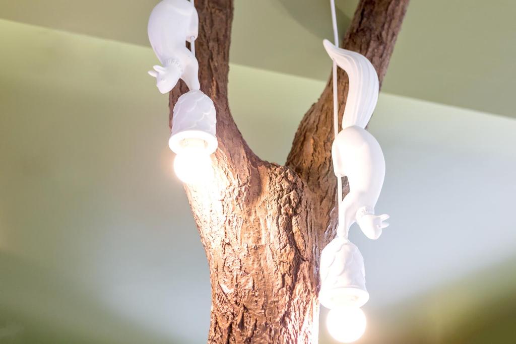 A sculptural indoor tree is wrapped with white decorative lights in a hotel interior.