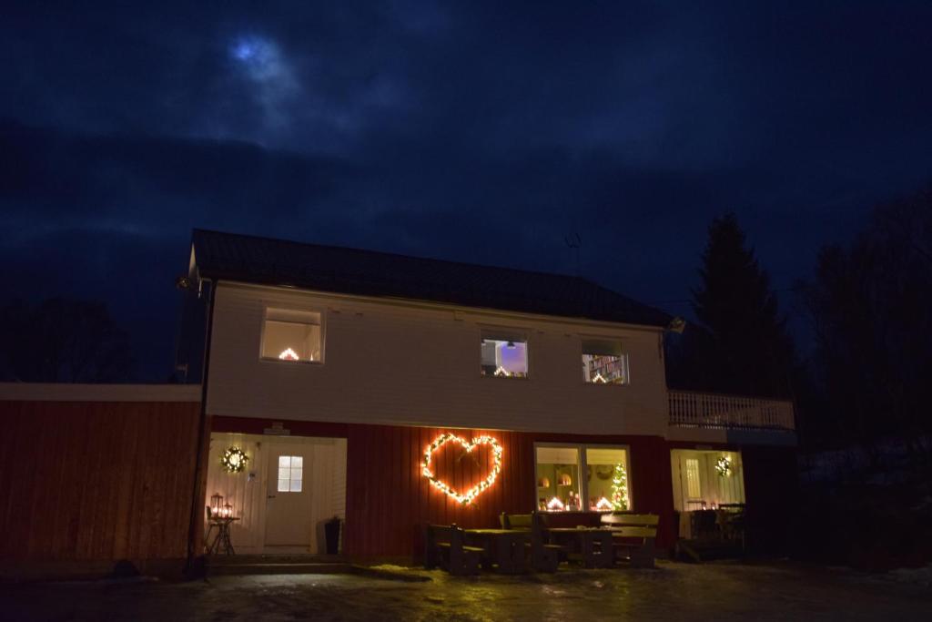 a house with a heart sign in the window at night at Captains House in Hamneide