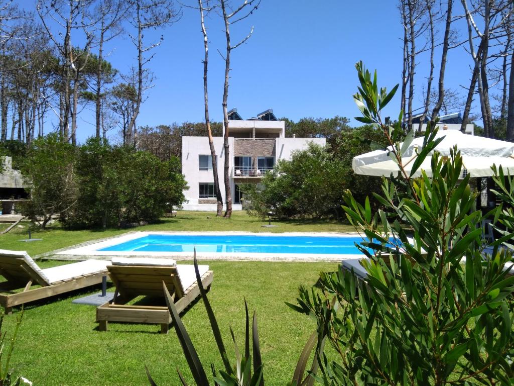 a villa with a swimming pool and a house at Pinar del Oriental in José Ignacio