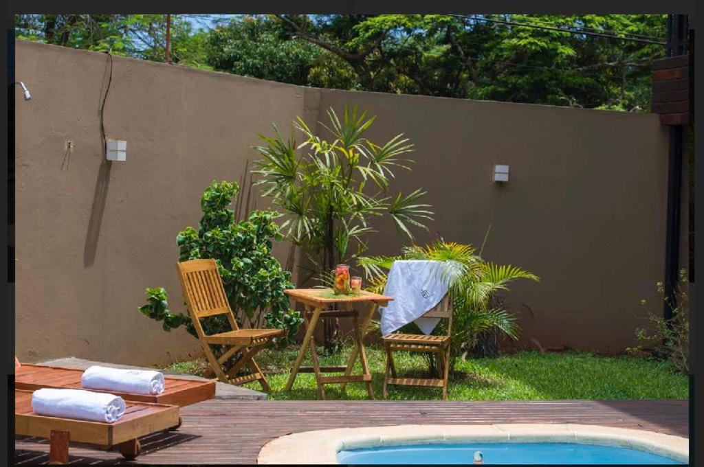 a patio with a table and chairs next to a pool at Iguazú Urban Hotel Express in Puerto Iguazú