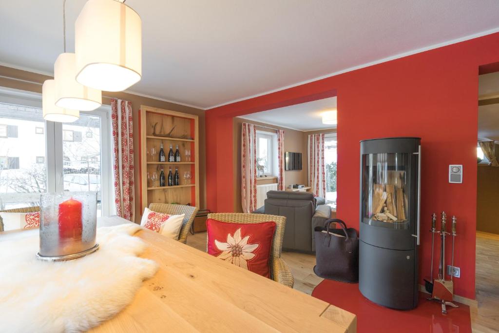 una sala da pranzo con tavolo in legno e pareti rosse di Chalet Alpin a Oberstdorf