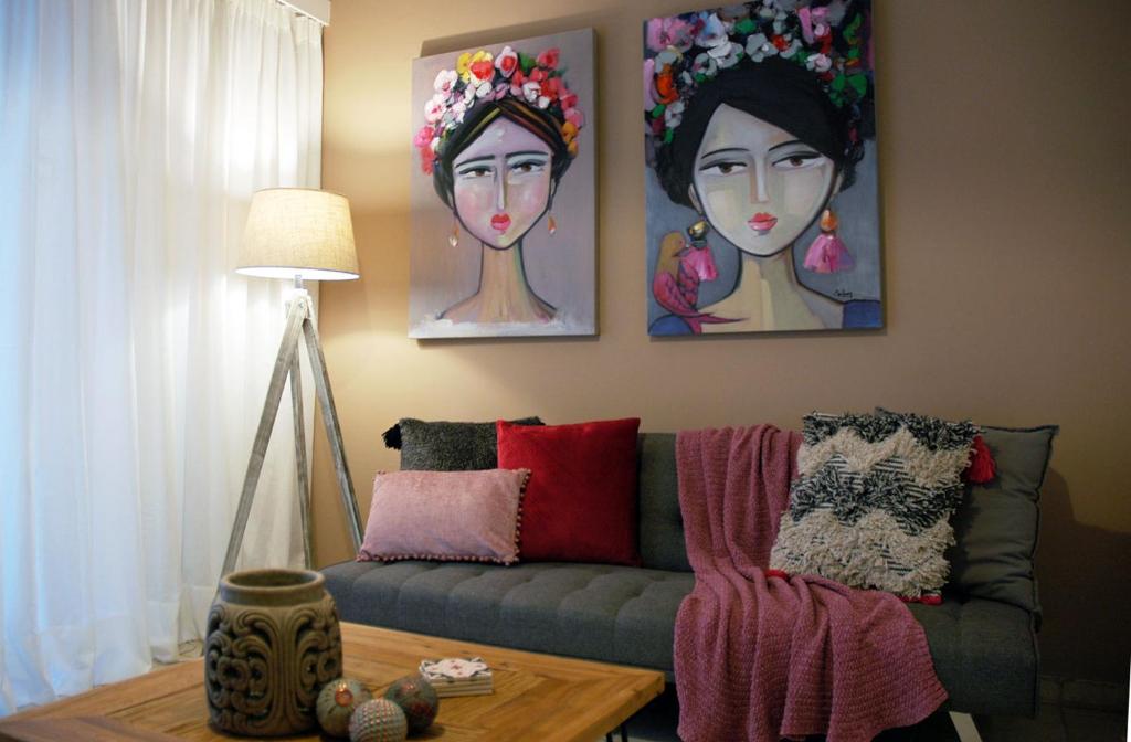 a living room with a couch and paintings on the wall at Acropolis, Urban Lifestyle apartment in Athens