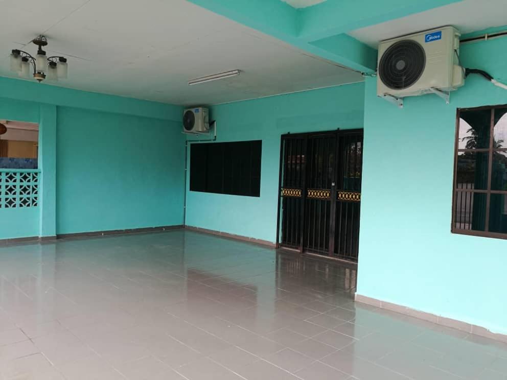 uma sala vazia com paredes azuis e uma coluna na parede em Teratak Port Dickson Homestay Mus Only em Port Dickson