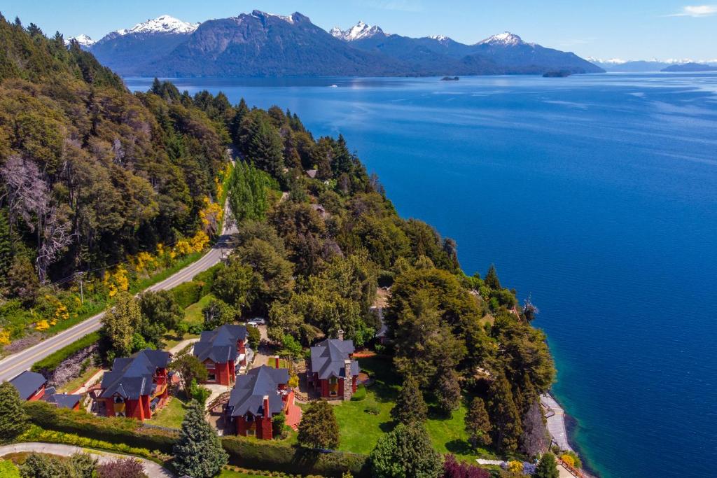 an aerial view of a house on a hill by the water at Costa Brava Apart Hotel & Suites in San Carlos de Bariloche