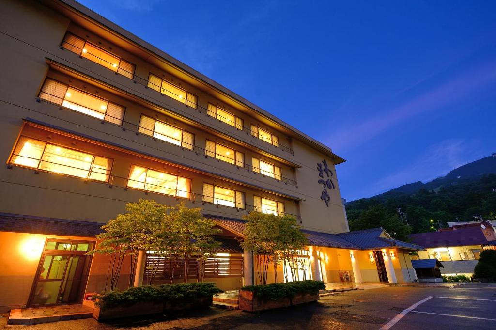 a large building with lights on at night at Wakamatsuya in Zaō Onsen