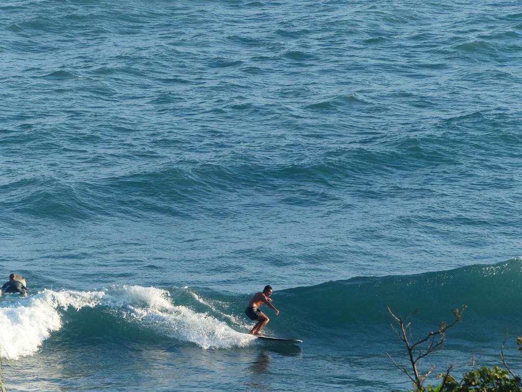 a man riding a wave on a surfboard in the ocean at La View 麗晨 Homestay in Manzhou