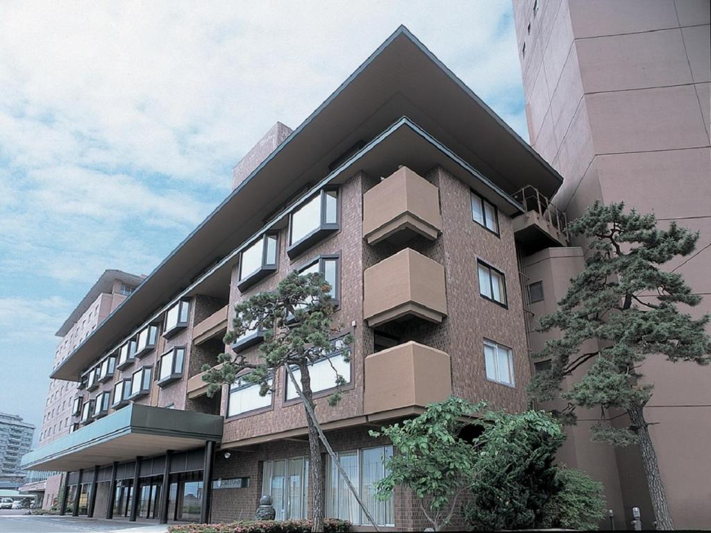 a tall building with a pointed roof at Yunokawa Kanko Hotel Shoen in Hakodate