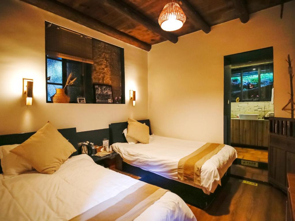 Postel nebo postele na pokoji v ubytování Tulou Herongzhuang Inn