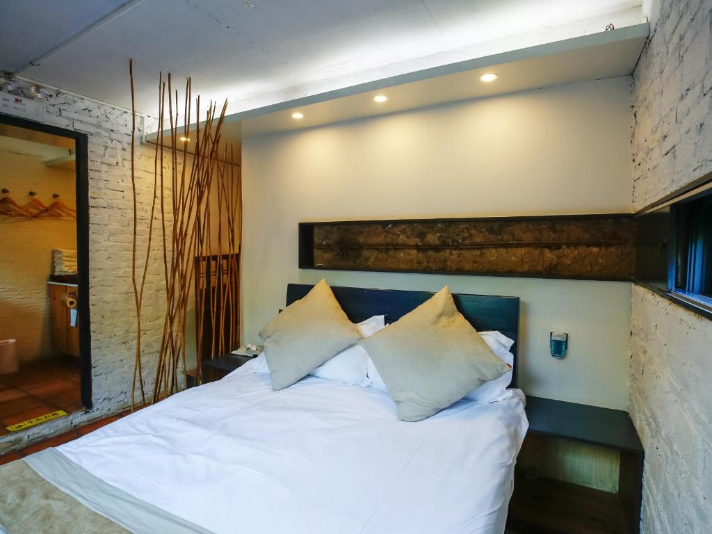 Postel nebo postele na pokoji v ubytování Tulou Herongzhuang Inn