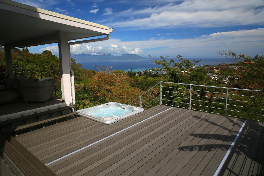 a deck with a hot tub on top of it at Ocean view & spa in Punaauia