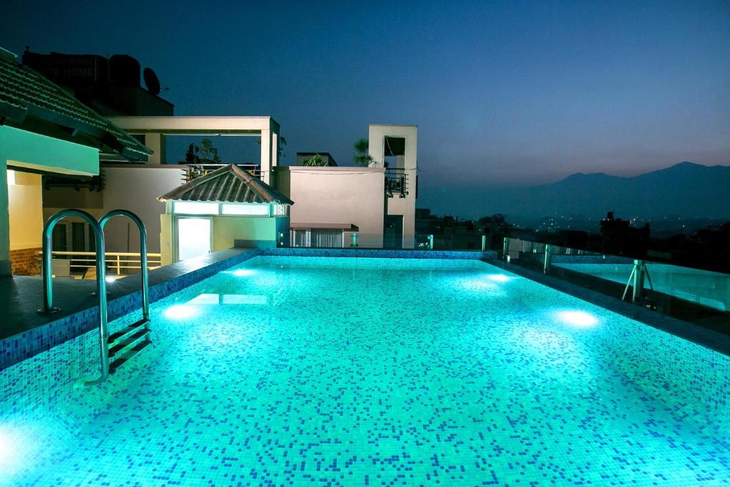 a swimming pool lit up at night on a house at Beautiful Kathmandu Hotel in Kathmandu