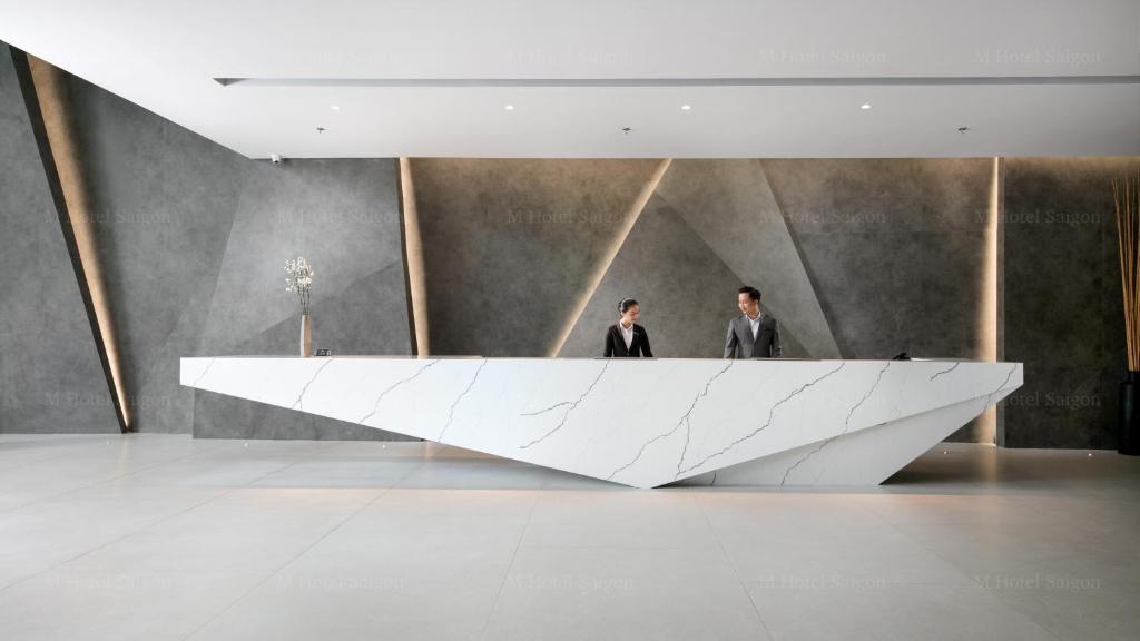 two men in a room with a large white sculpture at M Hotel Saigon in Ho Chi Minh City