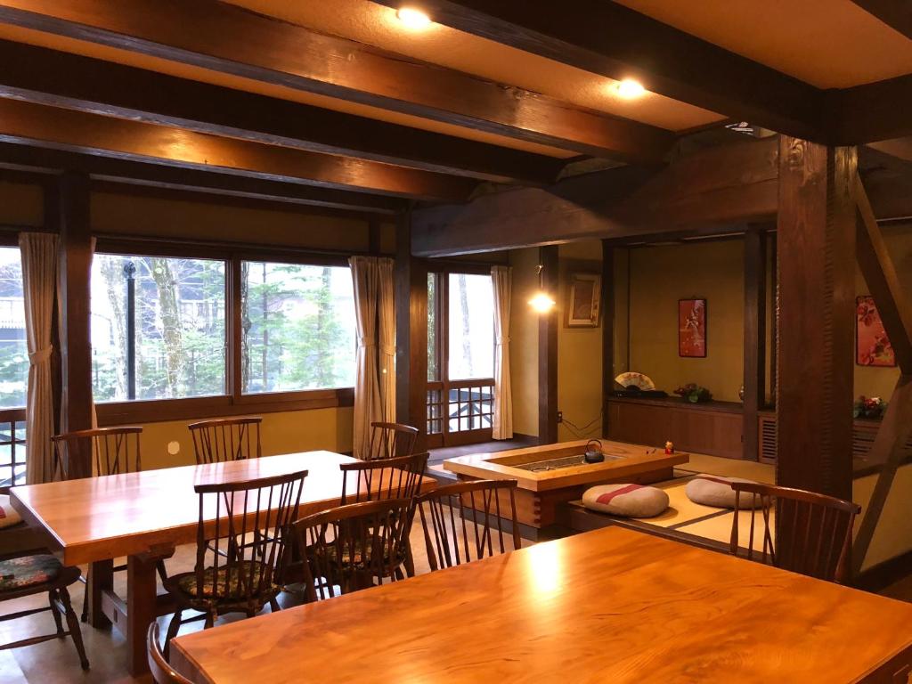 comedor con mesas y sillas de madera en The Guest House Japan Hakuba en Hakuba
