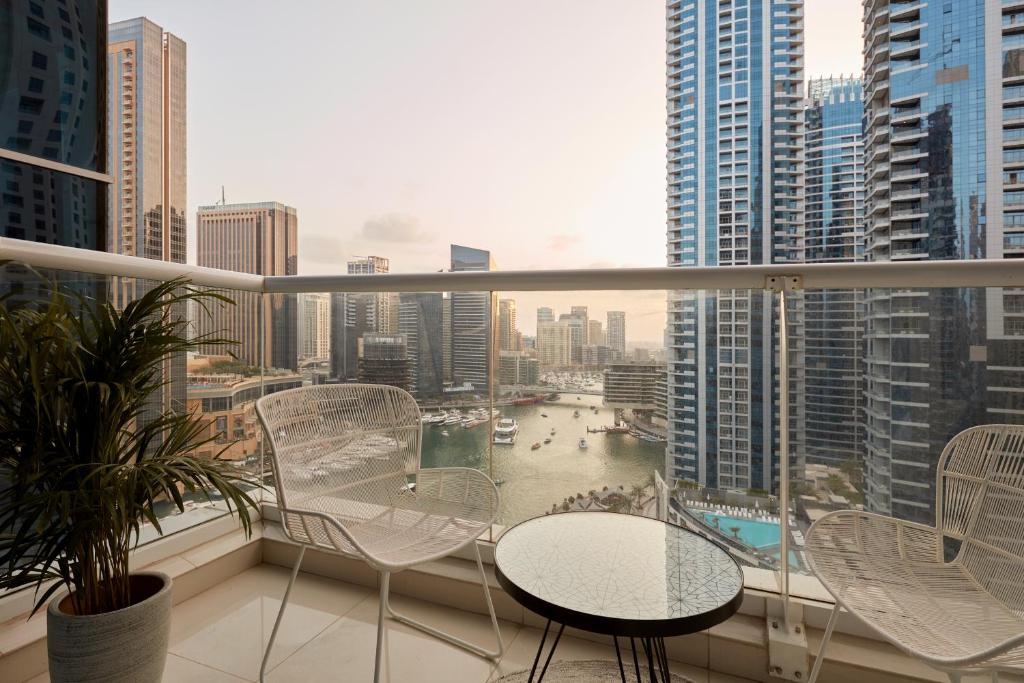 a balcony with a table and chairs in a city at Fantastay - Clara Dubai Marina in Dubai