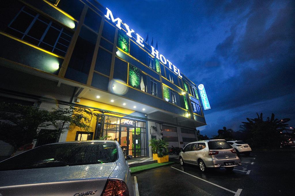 a building with cars parked in front of it at MYe Hotel in Muar