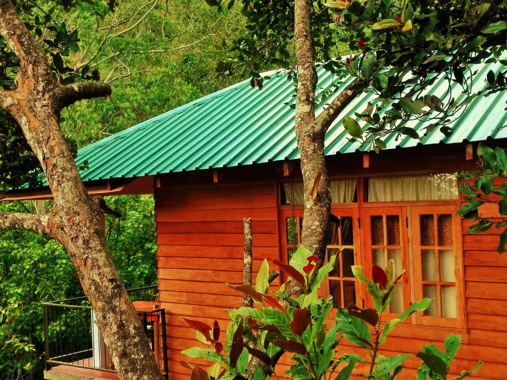 Cabaña roja pequeña con techo verde en Ella Green Cottages, en Ella