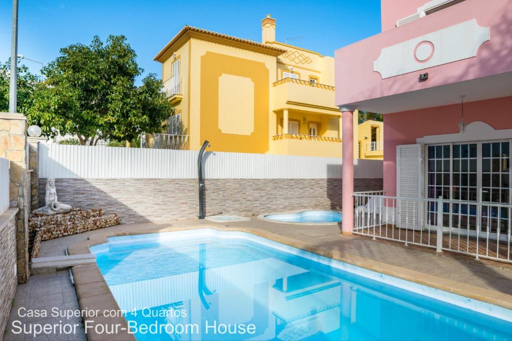 a villa with a swimming pool in front of a house at Akivillas Albufeira Star in Albufeira