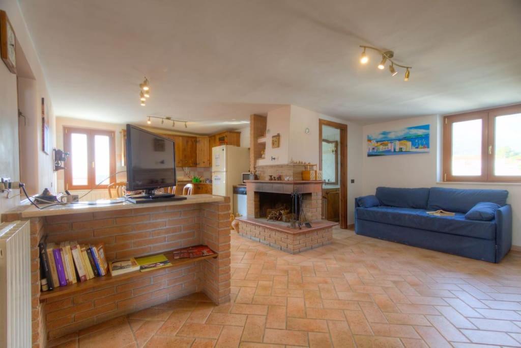 a living room with a blue couch and a fireplace at Appartamento a pochi passi dal mare in Formia