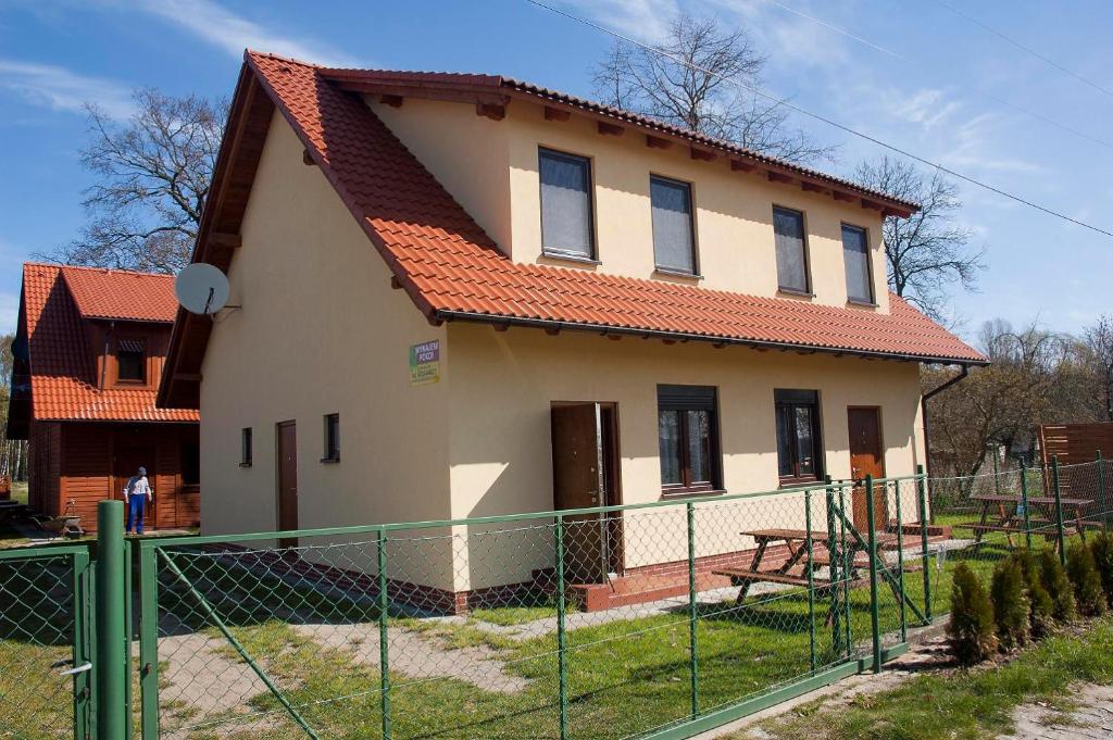 a house with a fence in front of it at Apartamenty pod lipą in Łukęcin