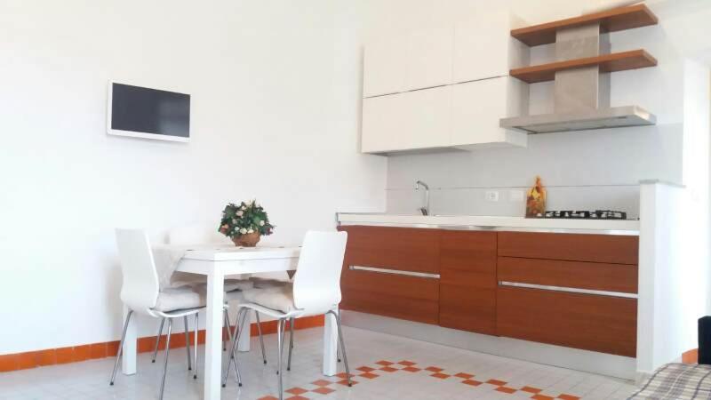 a kitchen with a white table and white chairs at Lerici al bacio in Lerici