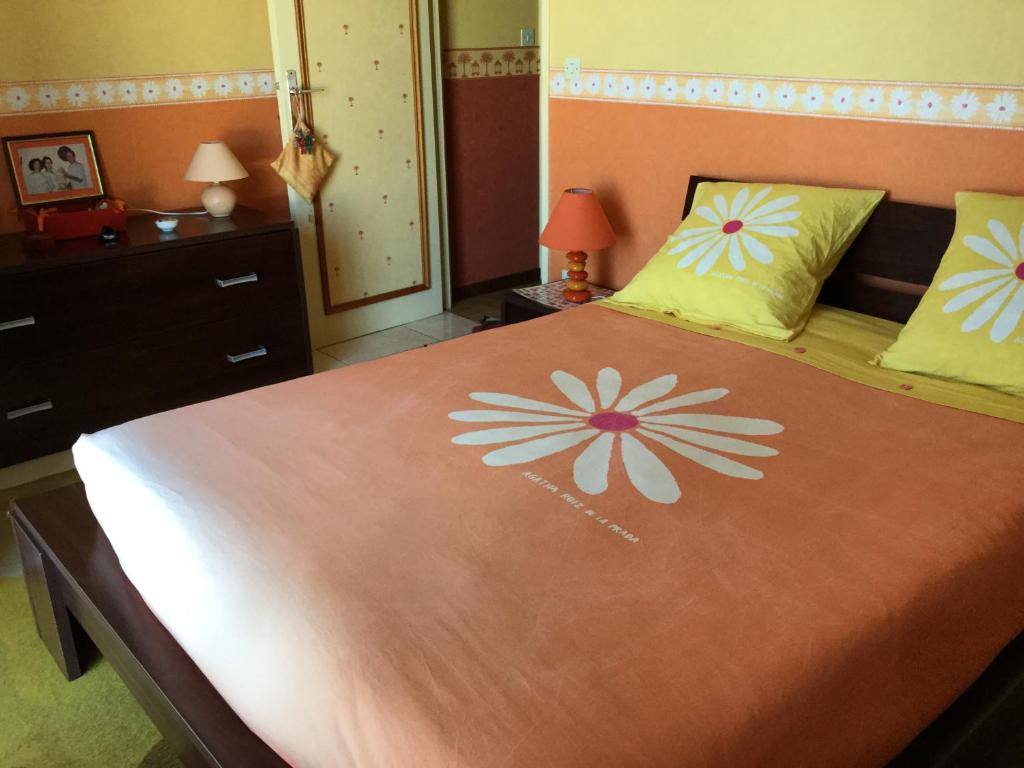 um quarto com uma cama grande com flores em Chambre et pièce confort em La Possession