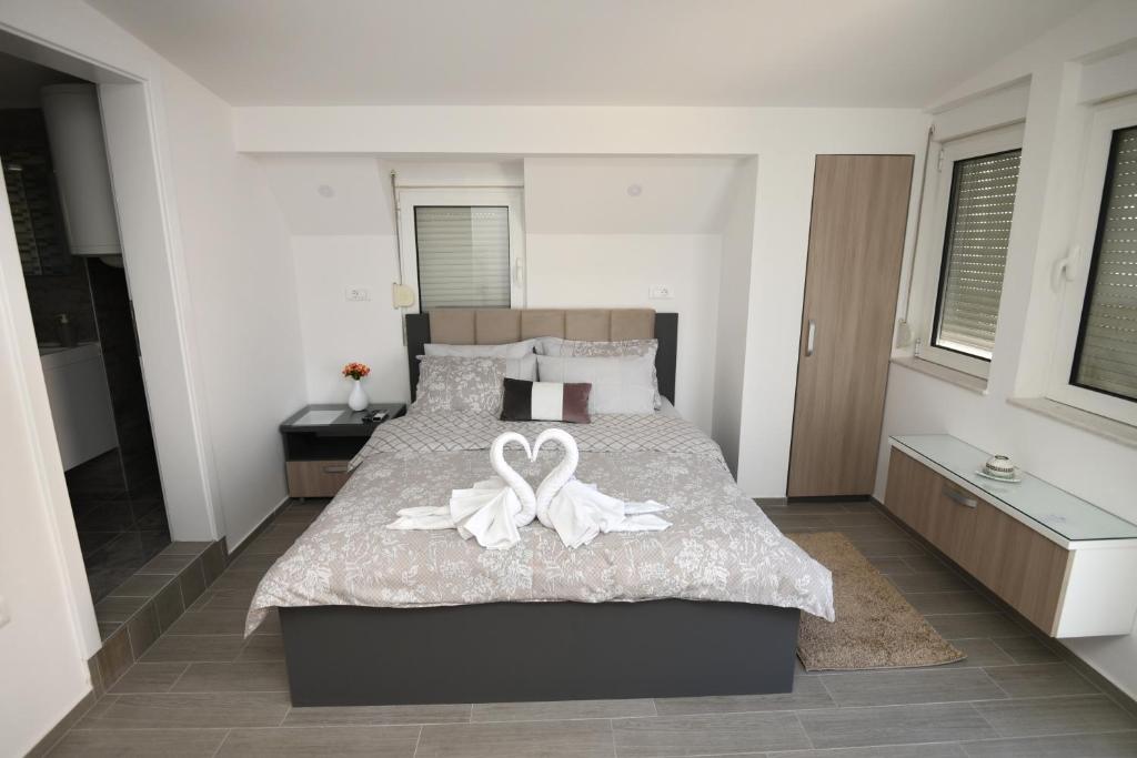 a bedroom with a bed with two white bows on it at Kate Apartments in Ohrid