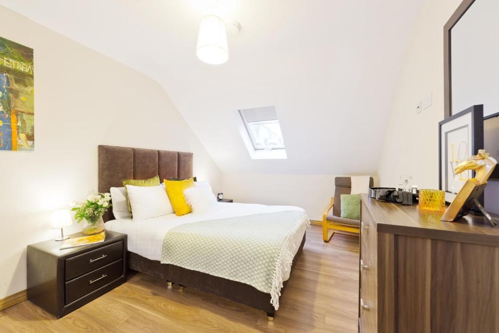 a bedroom with a bed and a dresser at Five Lamps Suites in Dublin