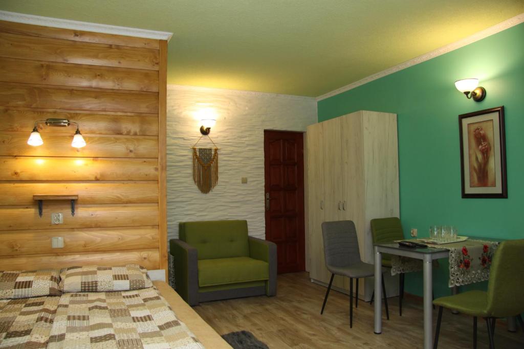 a bedroom with a bed and a table and chairs at Pokoje Gościnne in Niedzica Zamek