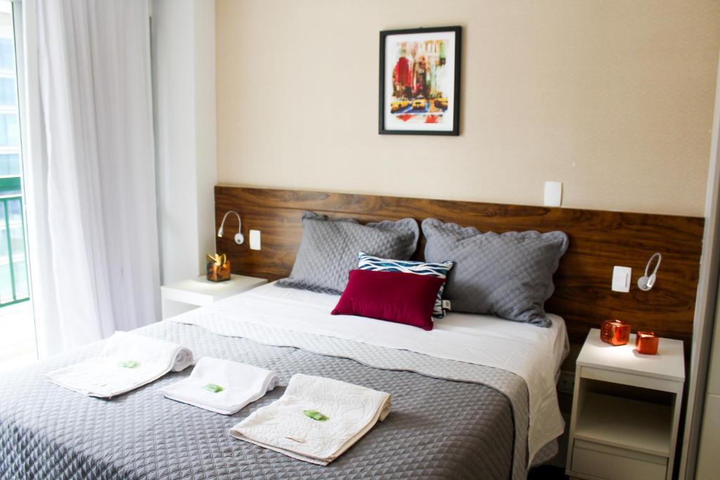 a bedroom with a large bed with two towels on it at Brasilia Boutique Flats in Brasilia