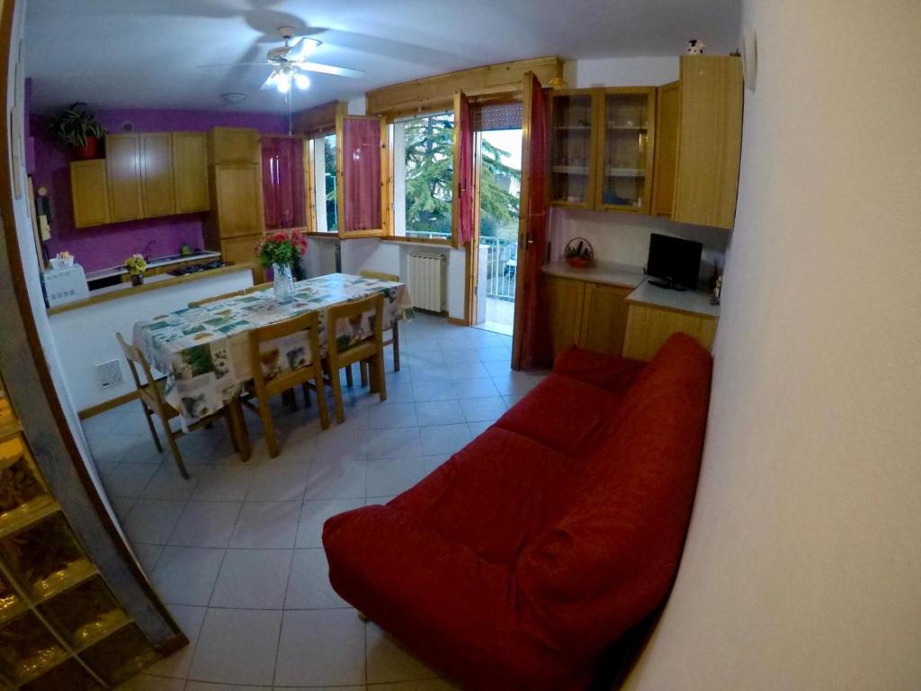 リミニにあるCasa Vacanze Musianiのリビングルーム(赤いソファ付)、キッチン