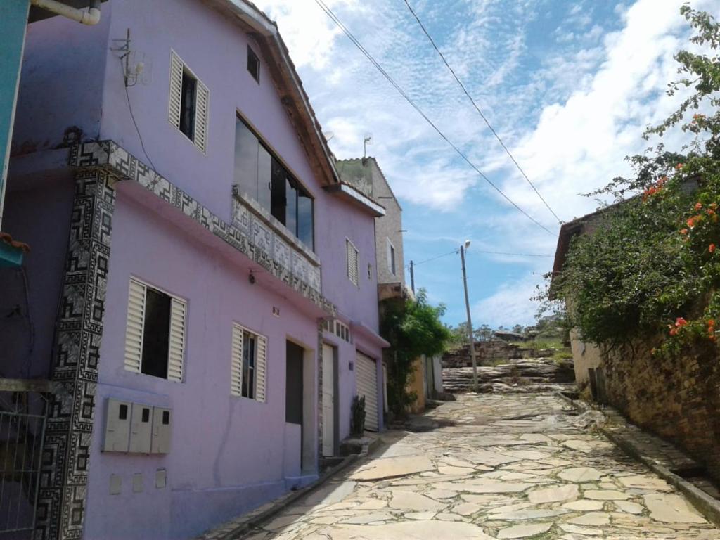 um beco com um edifício cor-de-rosa numa rua em Hospedaria Oliveira em São Tomé das Letras