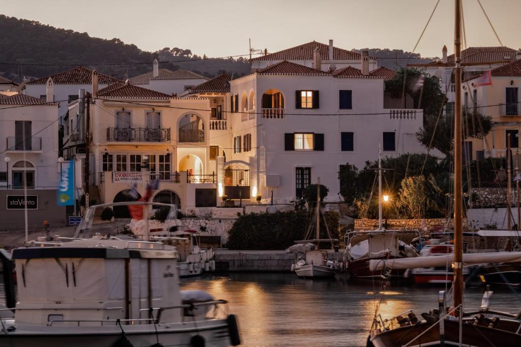 a group of boats docked in a marina with buildings at Porto Vecchio Luxury Suites in Spetses
