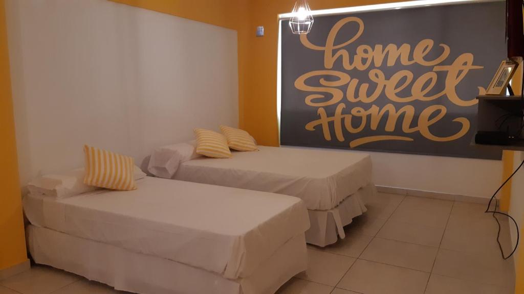 a room with two beds and a sign that says home sweet home at LAS PIEDRAS DESIGN II in San Miguel de Tucumán