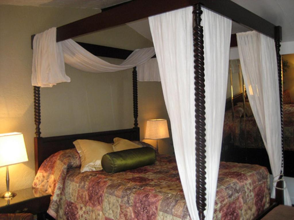 una camera con un grande letto a baldacchino di Motel Iberville a Saint-Jean-sur-Richelieu