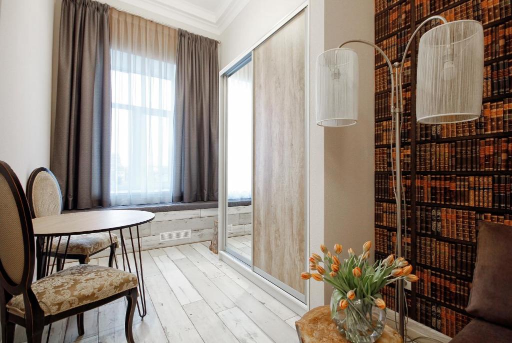 a living room with a table and chairs and a window at D5 Apartments in Odesa