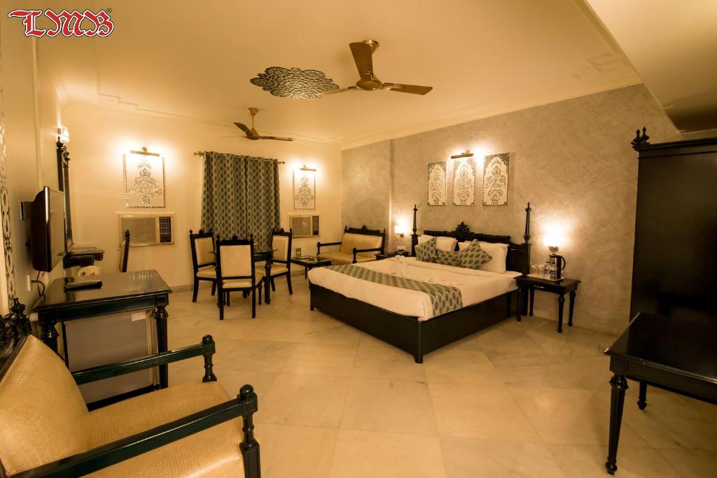 a bedroom with a bed and a living room at LMB Hotel City Centre, Jaipur in Jaipur