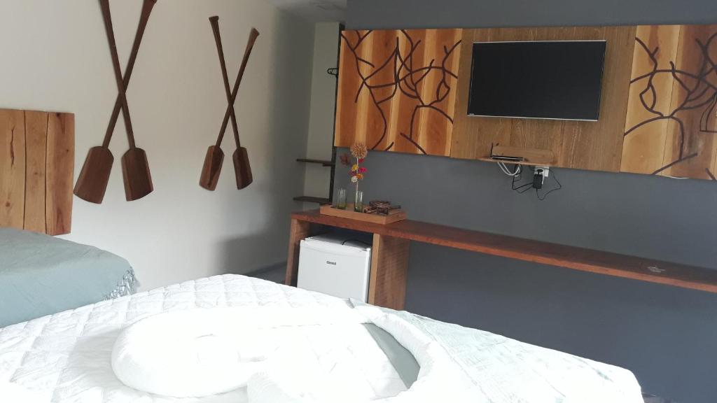 a bedroom with a bed and a tv on the wall at Pousada Beira Rio Parnaíba in Parnaíba
