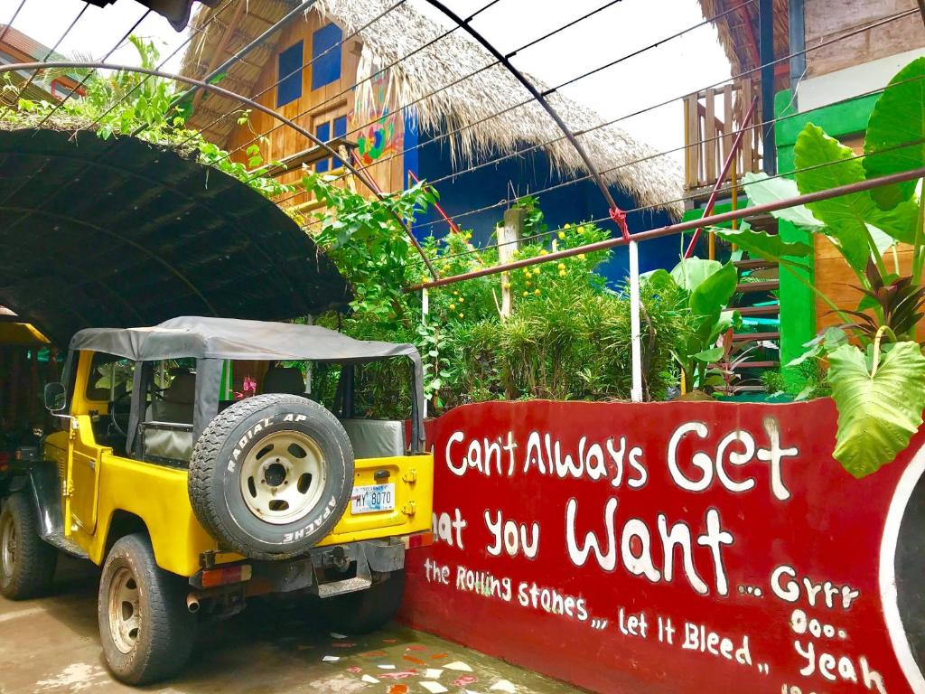 a small toy jeep parked next to a sign at Lazy Crab Hostel in Balgue