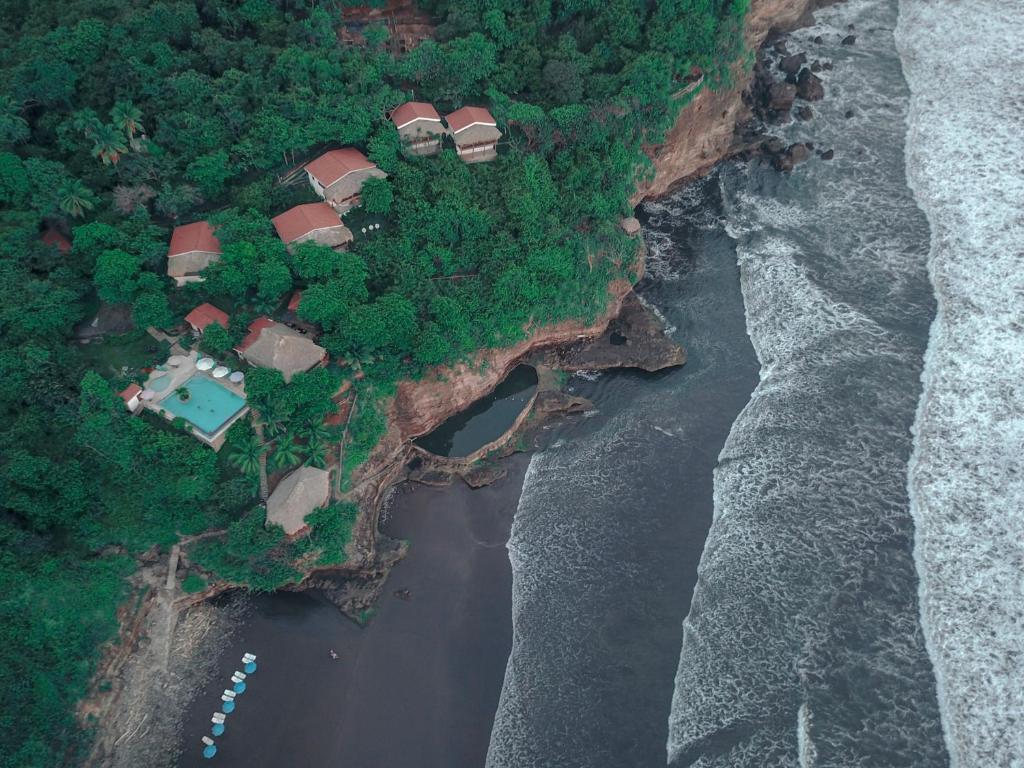 El Níspero的住宿－Paraiso Escondido Hotel Villas & Resort，靠近大海悬崖上房屋的空中景观