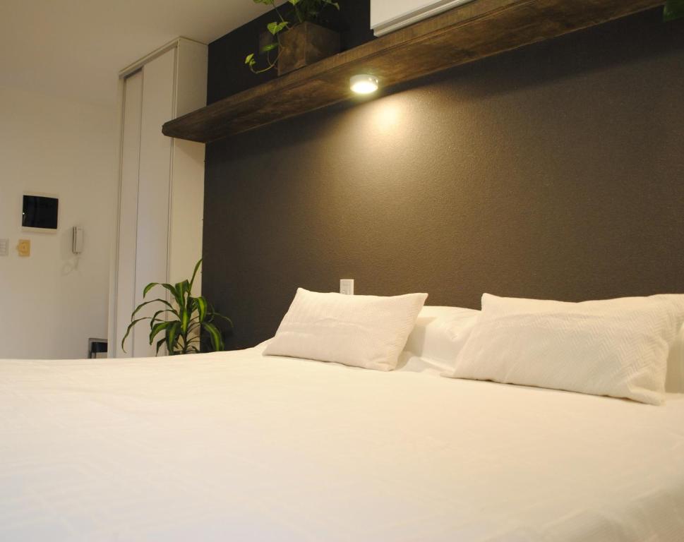 a white bed with white pillows on top of it at Dickens Apart in Salta