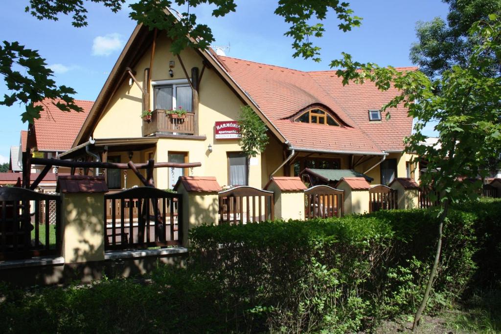 ein großes gelbes Haus mit rotem Dach in der Unterkunft Harmónia Apartman in Hajdúszoboszló