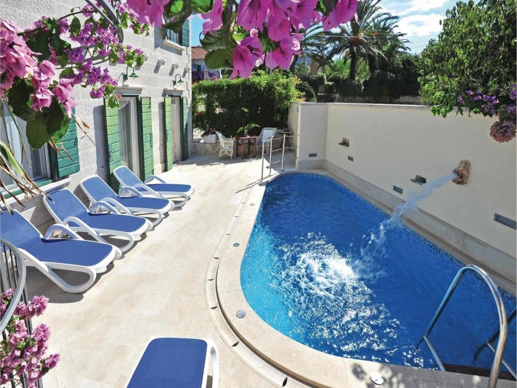 a pool with chaise lounge chairs and a swimming pool at Villa Angelina Supetar in Mirce